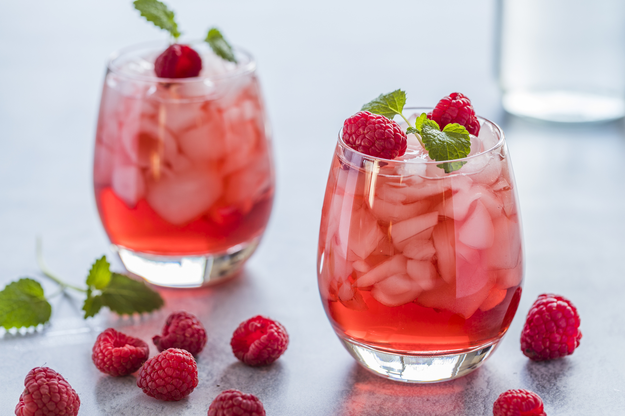 Refreshing red drink with fresh raspberries and crushed ice