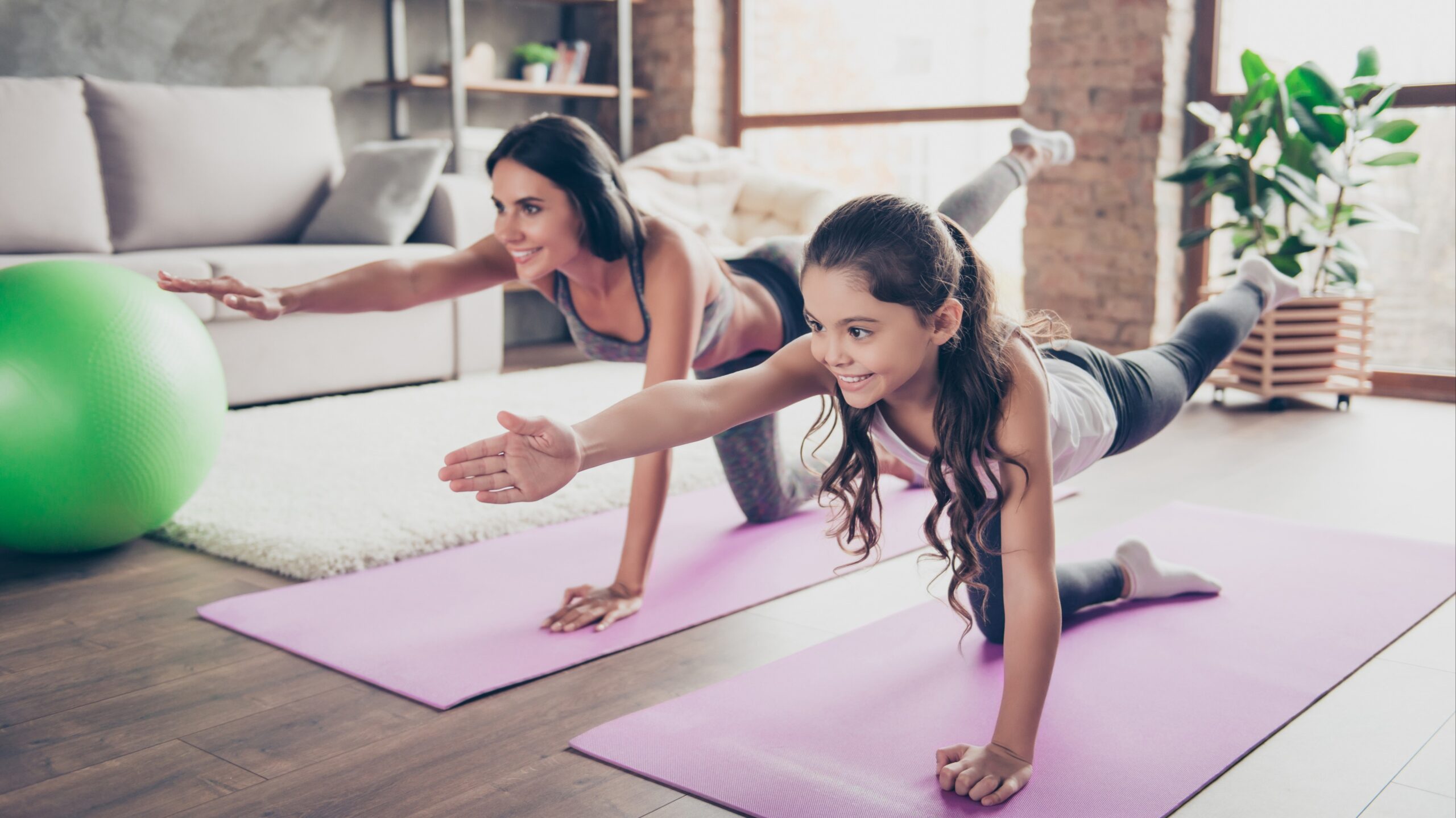 Mother and daughter doing yoga at home