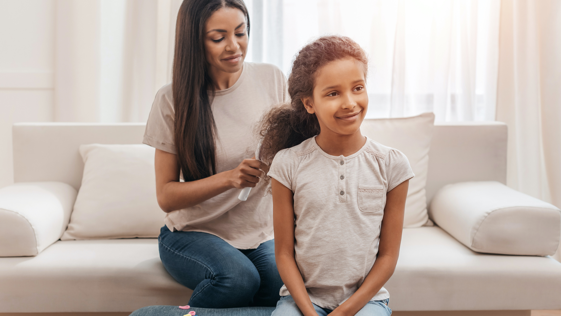 Mother combing her daughter's hair to make a hairstyle for girls with curly hair