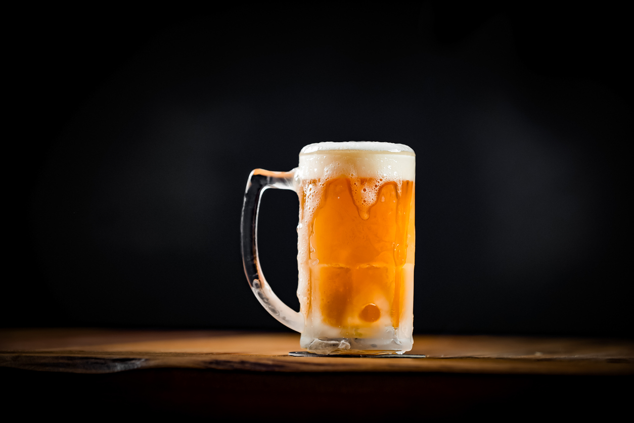 mug full of chopp, with chopp pilsen on a rustic table.