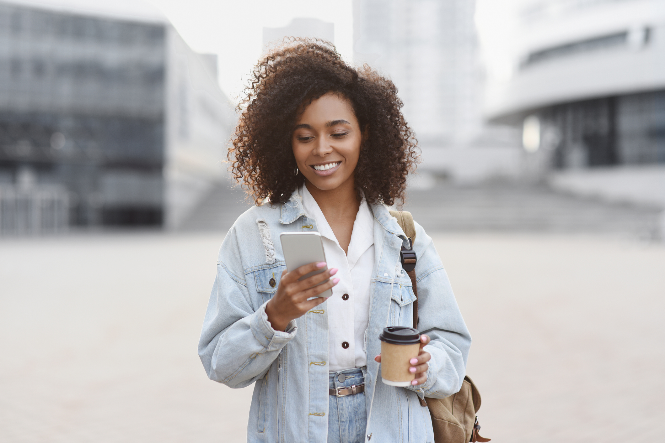 Young woman using smart phone on a city street