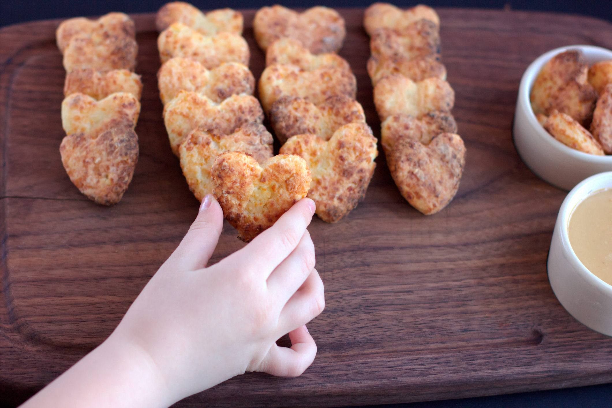 kid's hand taking heart shaped cookie