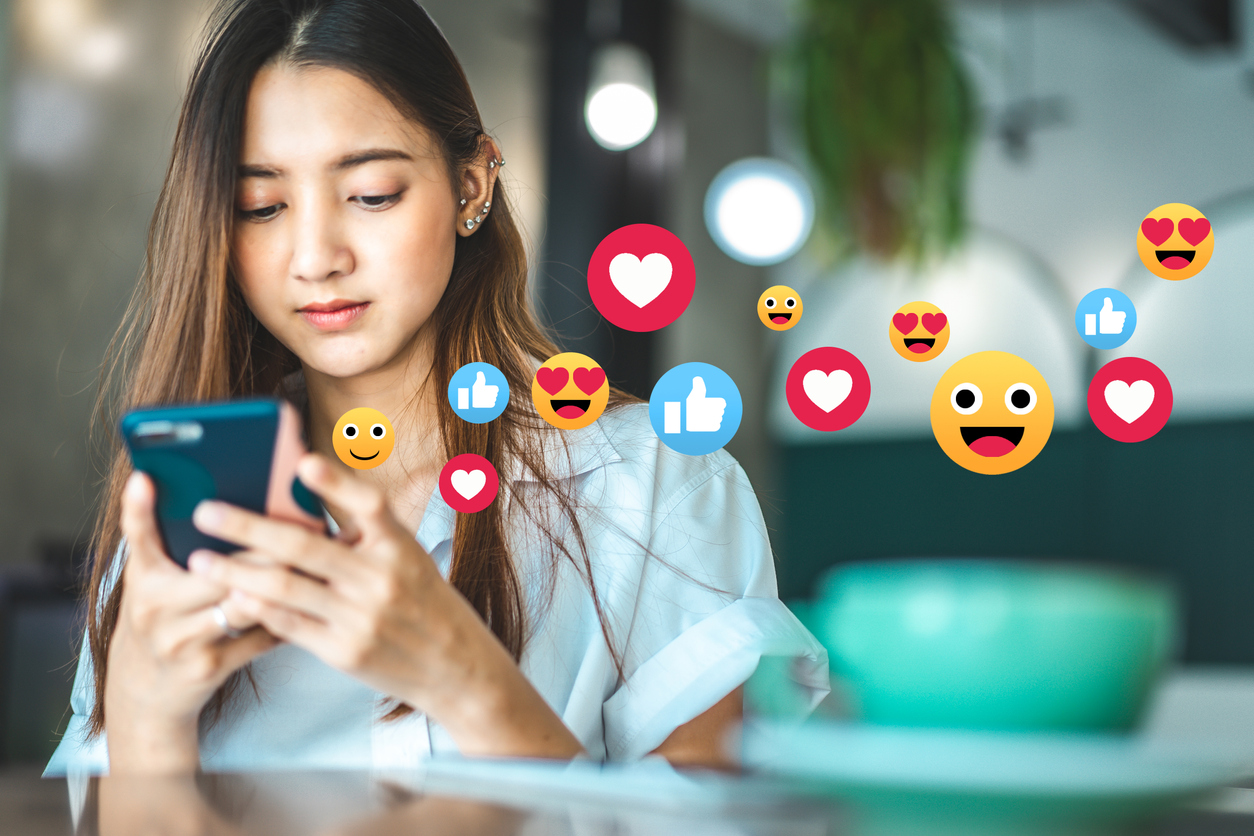 Asian woman in a cafe drinking coffee .Portrait of Asian woman smiling in coffee shop cafe vintage colour tone.Cheerful woman watching a video live streaming on her phone