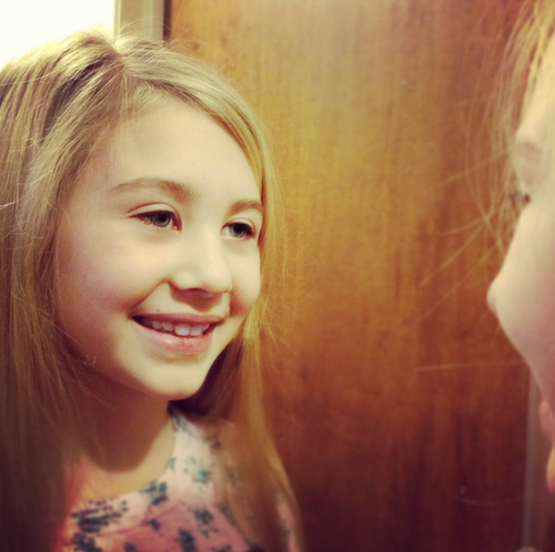 Little girl looking in the mirror