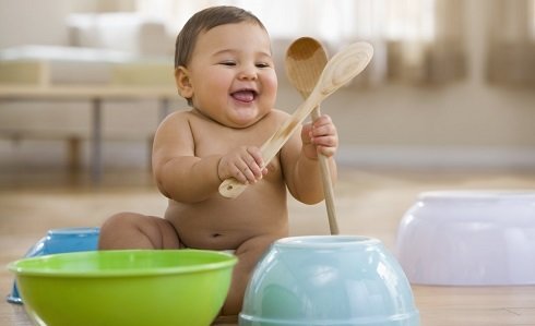 baby playing with spoons and bowls