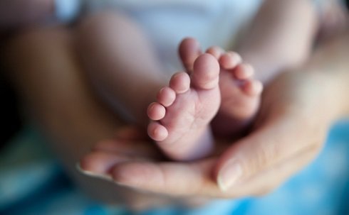 baby's feet in mother's hands