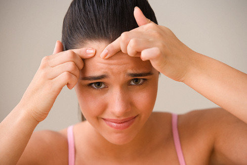 woman popping pimple