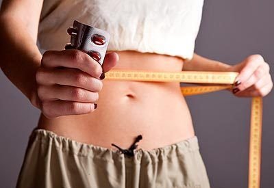 woman holding pill measuring tape