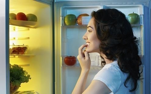 woman looking in refrigerator