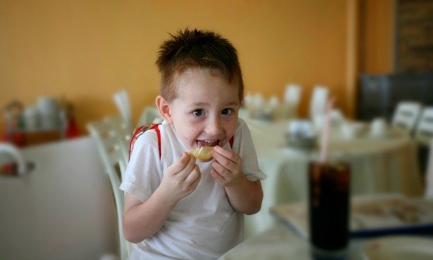 child eating lemon