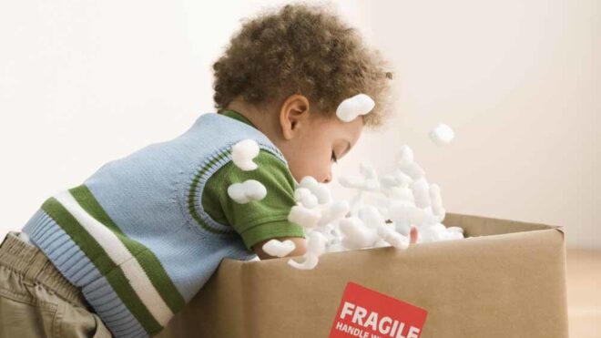 toddler playing with a box