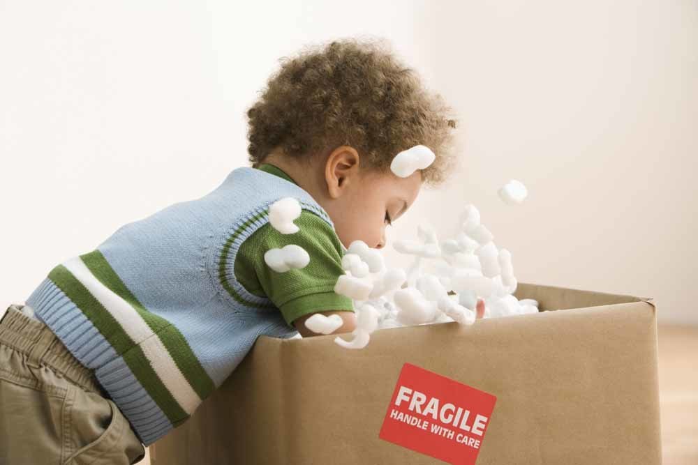 toddler playing with a box