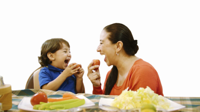 mama y niño comiendo tomates