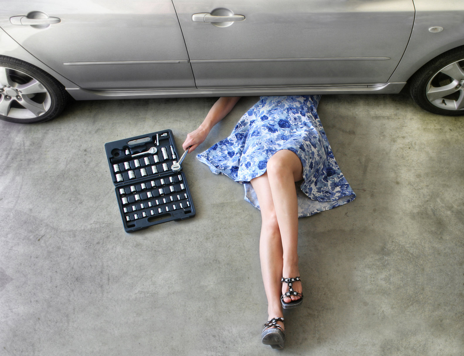 mujer debajo de carro