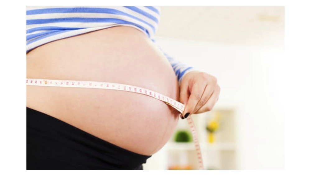 pregnant woman measuring belly