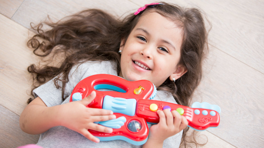 girl playing toy guitar