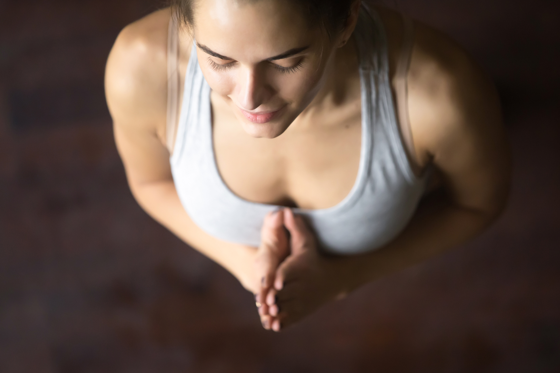 Top view of young woman in yoga pose with Namaste