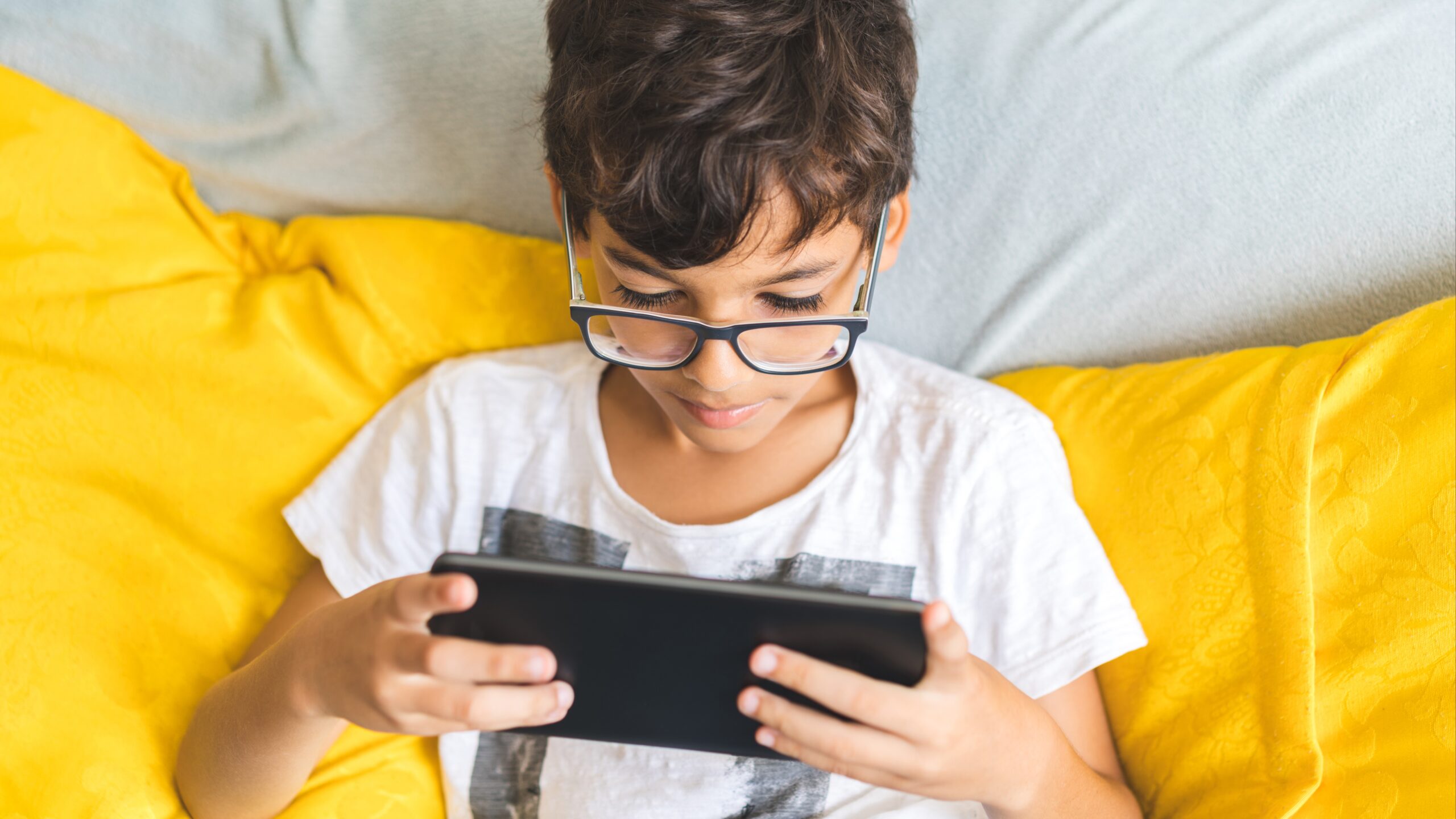 niño con lentes usando tablet