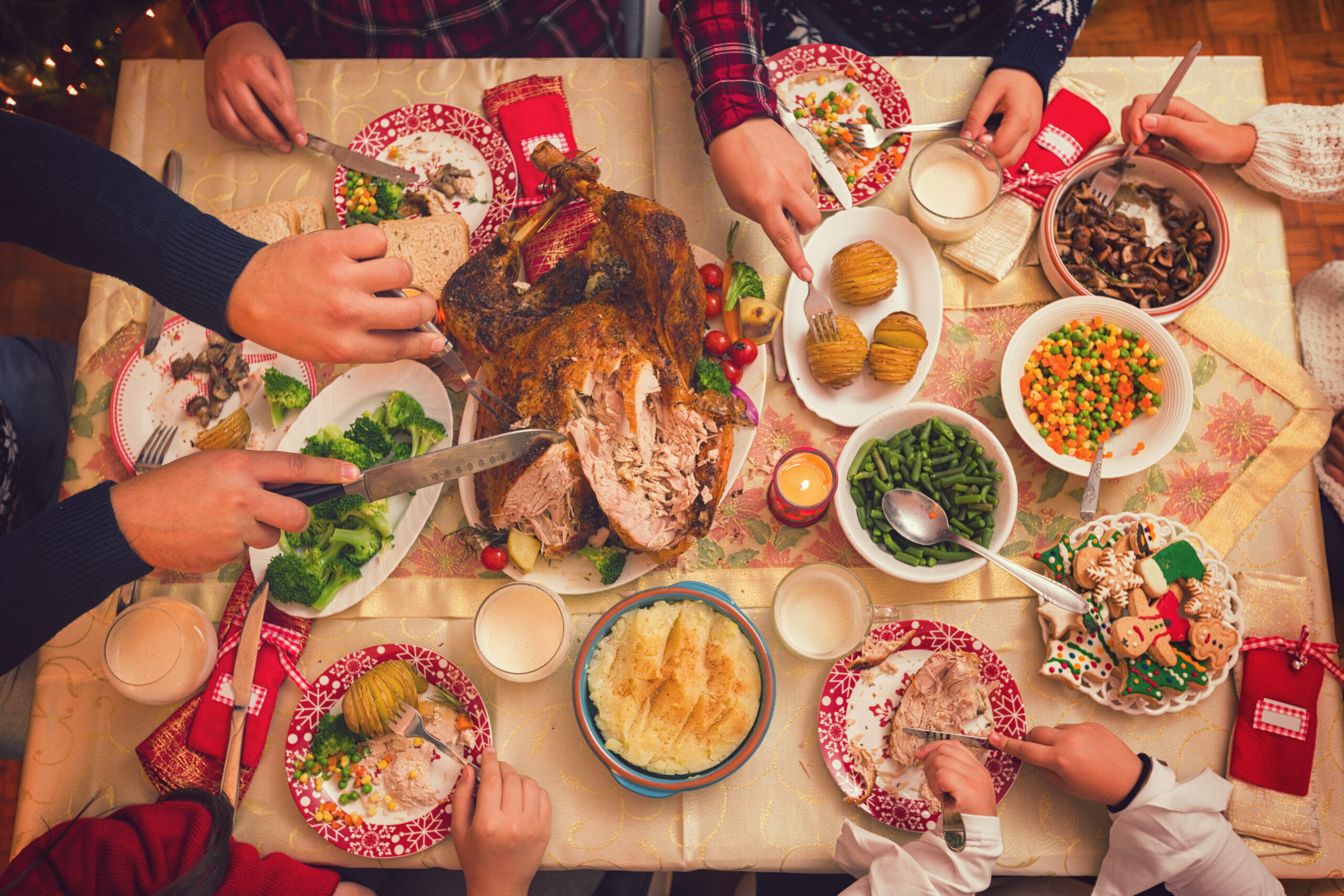 Young father carving stuffed roasted turkey for Christmas dinner