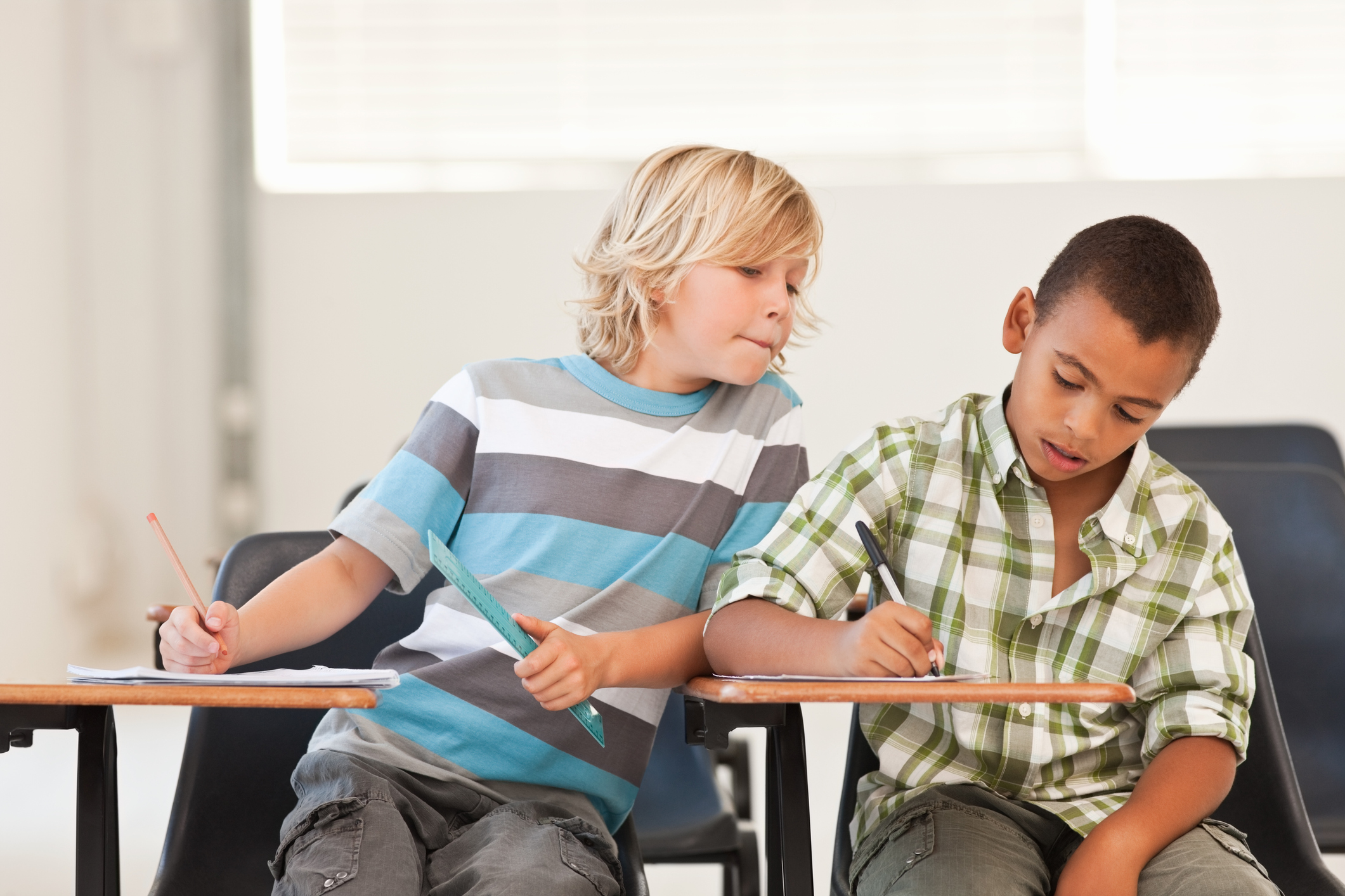 Little boy peeping in classmates examination paper