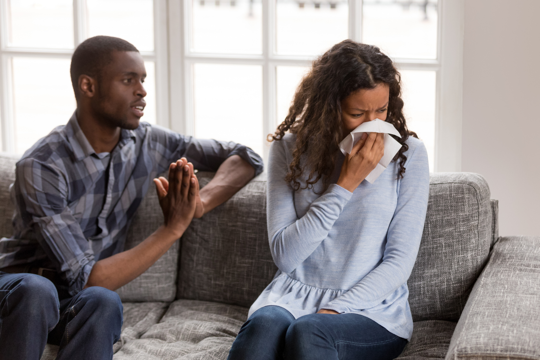 Frustrated African American man apologizing to woman after quarrel