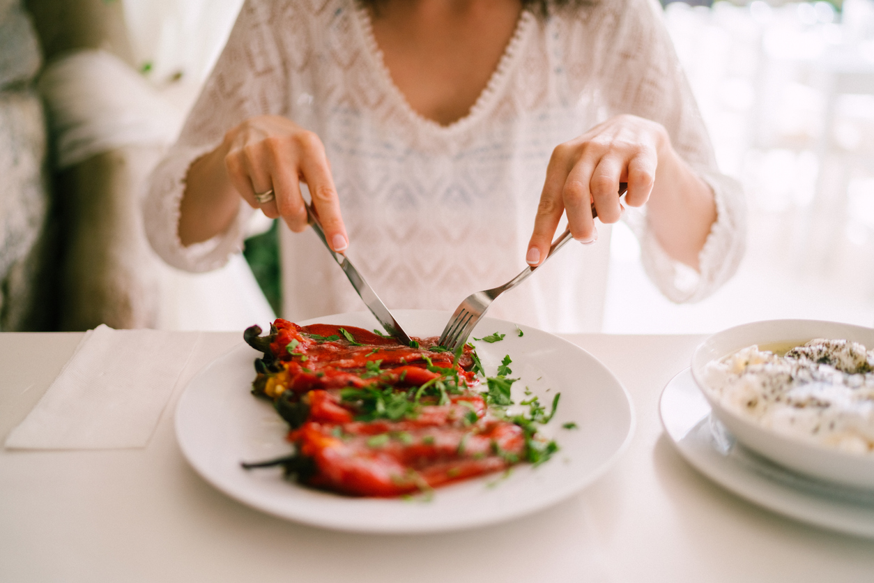 Tourist woman eating in restaurant