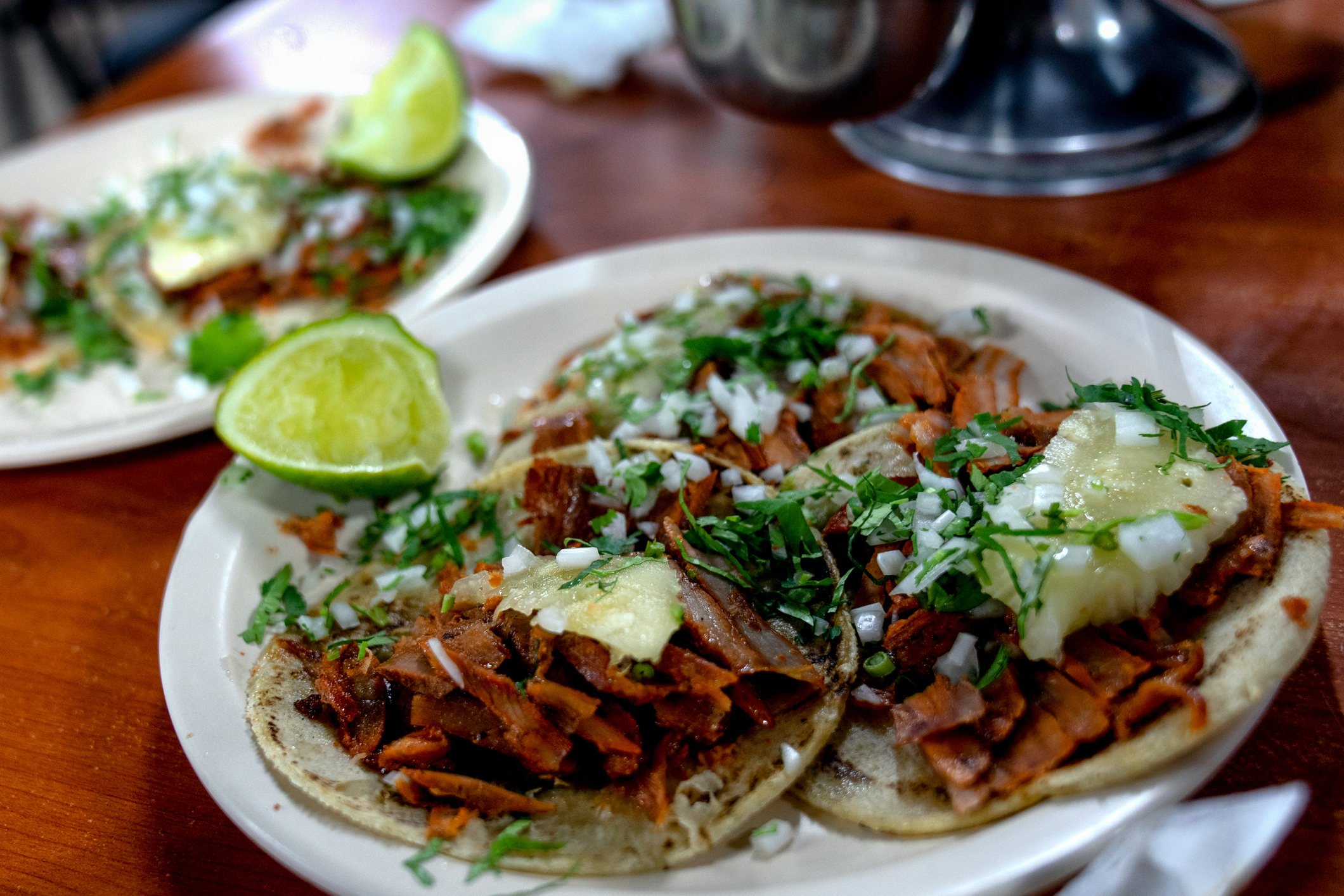 A Plate Of Tacos Al Pastor, Corn Tortillas, Shaved Pork, Sauce, Sliced Pineapple, Cilantro,Cheese And Lime