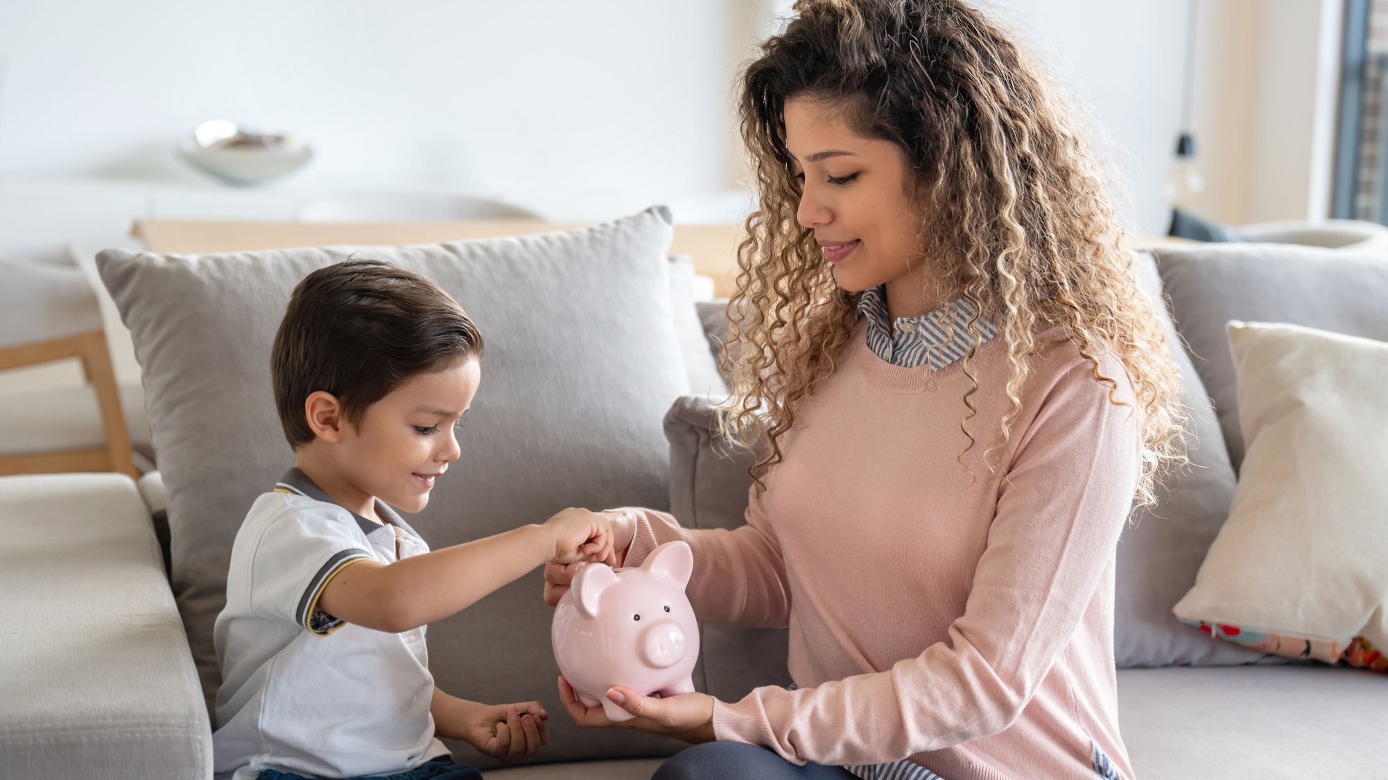 iStock-1132516159 mamá con hijo y alcancía