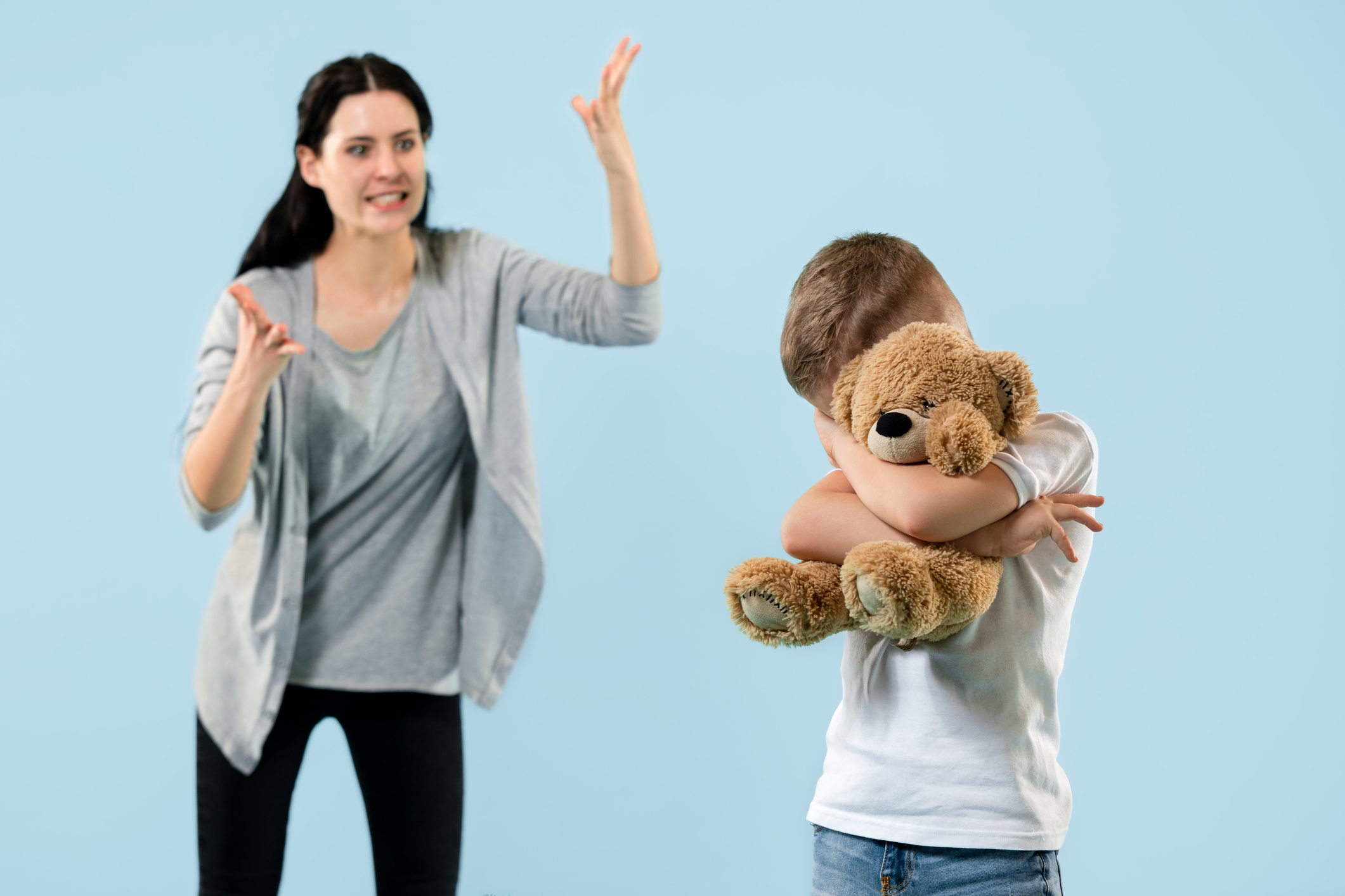 Angry mother scolding her son in living room at home