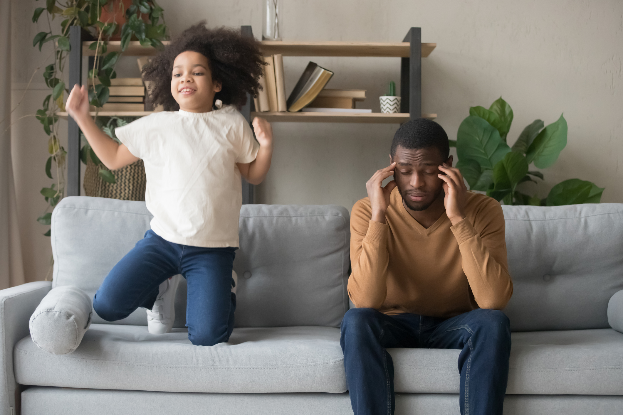 African American father having problem with noisy naughty daughter