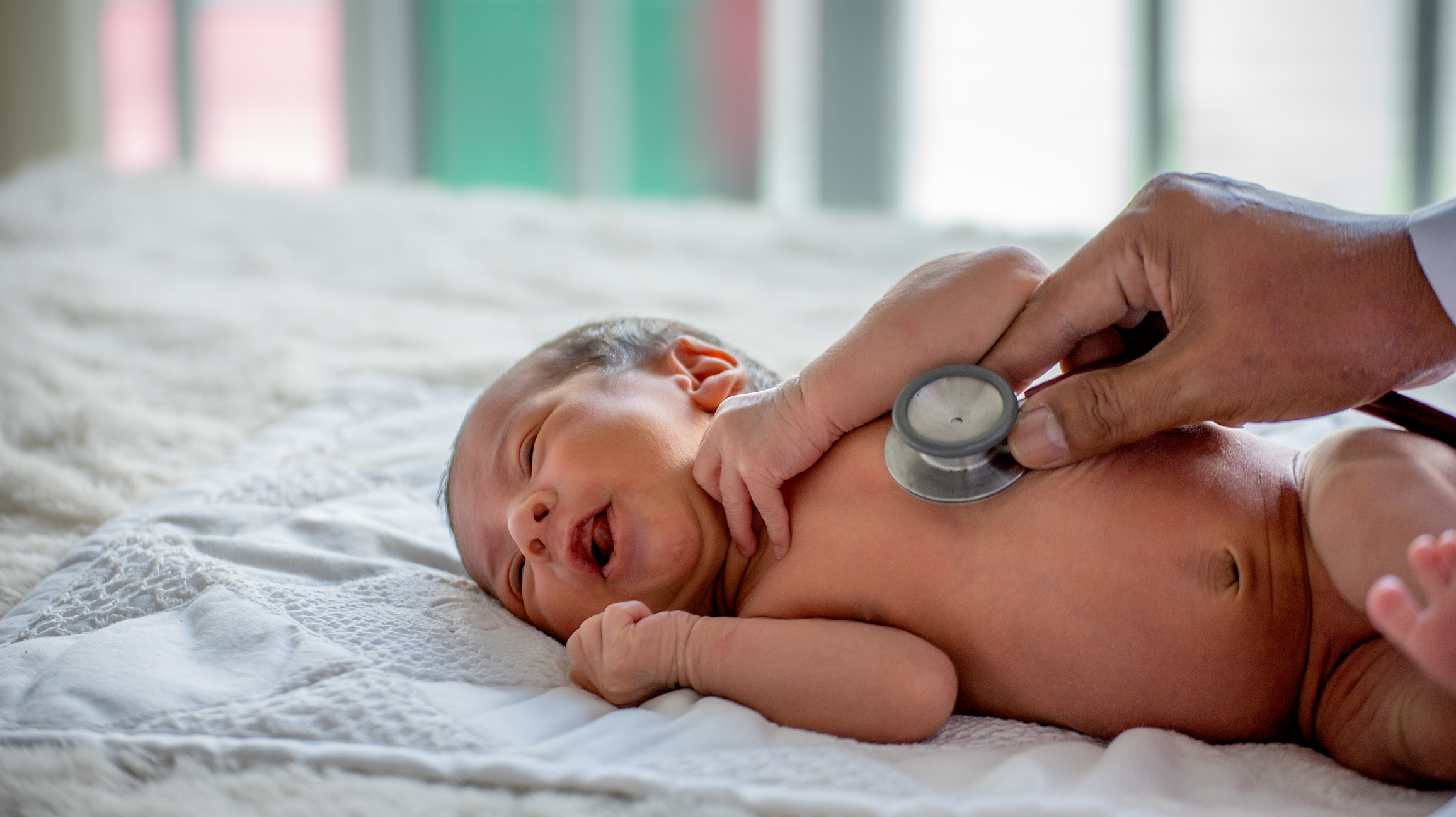 Soft blur of the doctor hands use stethoscope to check newborn baby health and take care him or cure the disease or disorder