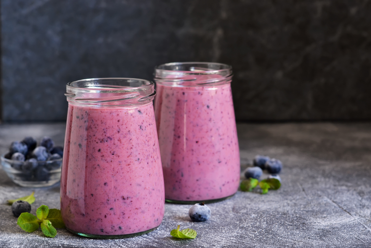 Purple smoothies with blueberries on the kitchen table. Detox menu.