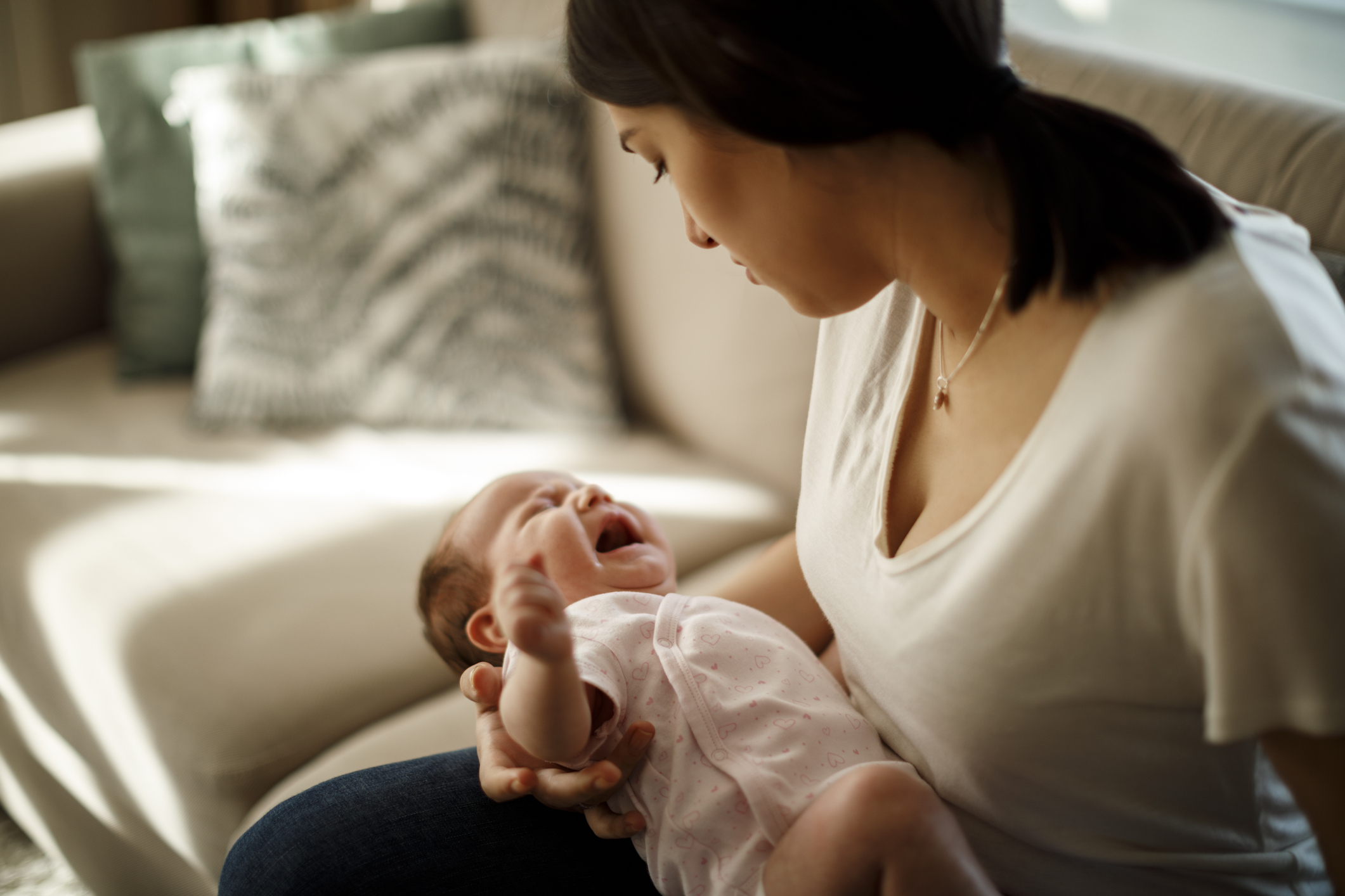 Newborn baby crying in mother hands