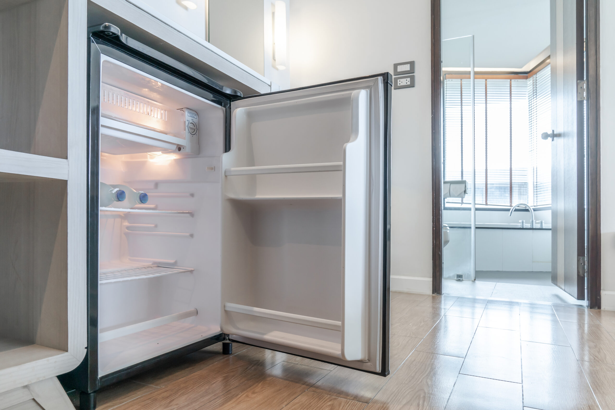 opened small refrigerator under the counter and in front of toilet in delux room at resort and hotel.