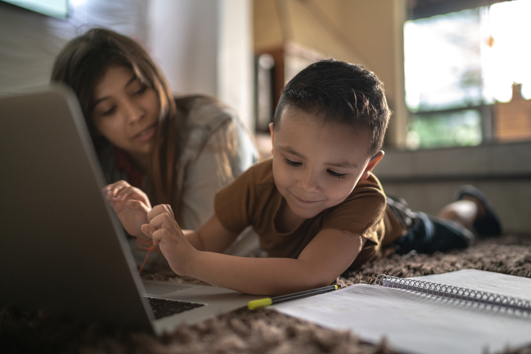 Teenager sister helping little brother with homework