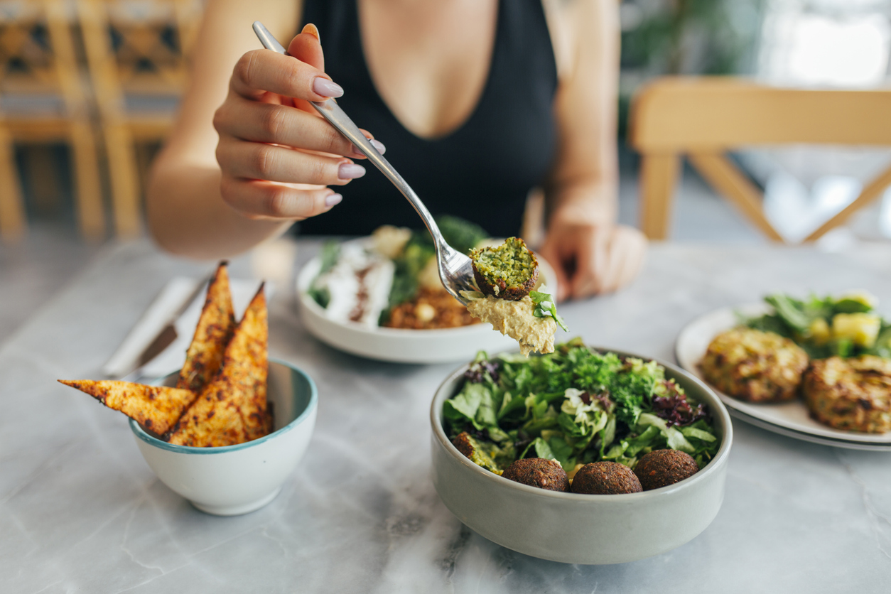 Woman Eating Falafel in a Restaurant