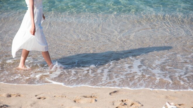 mujer caminando en la playa