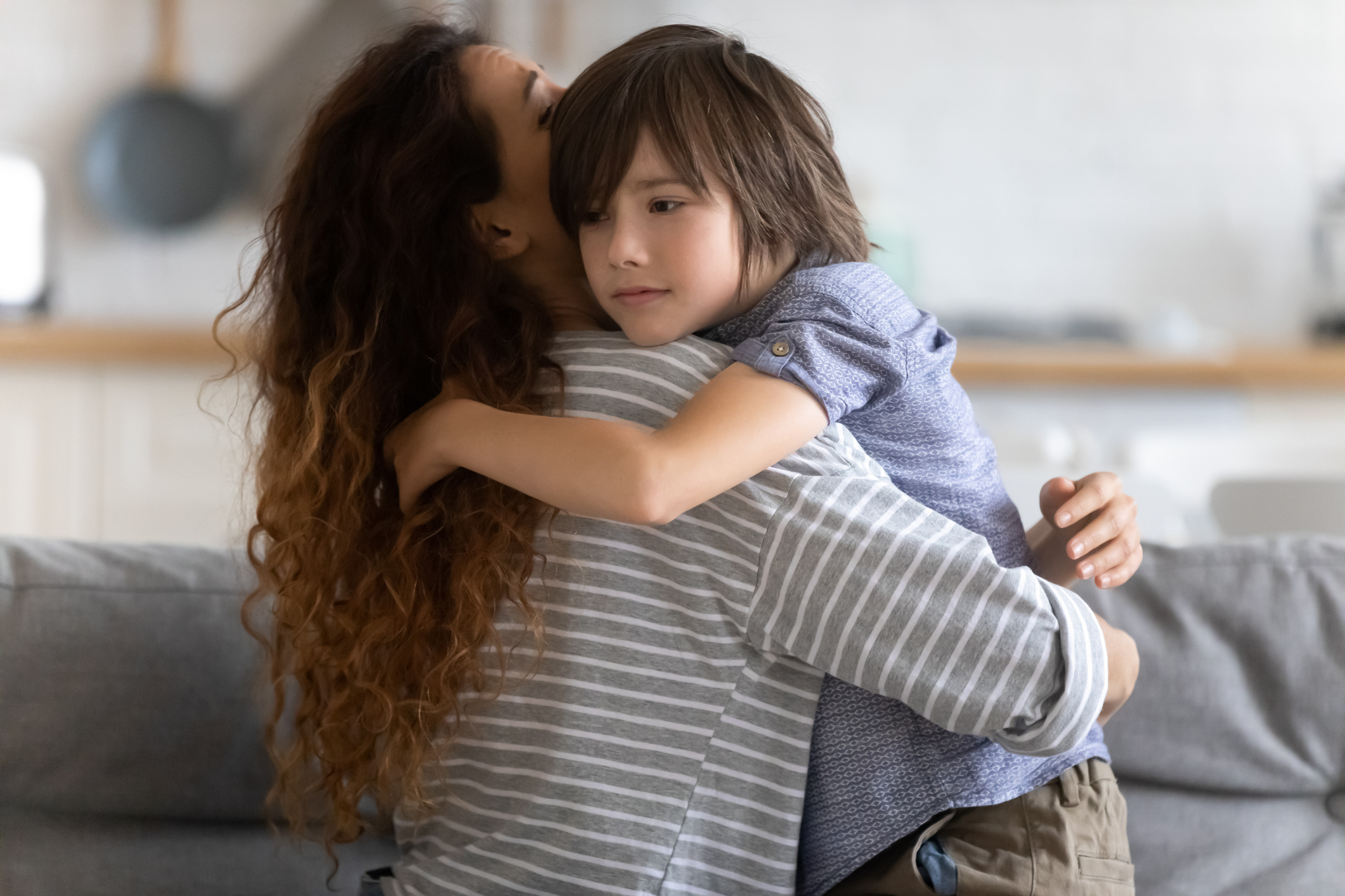 Close up caring young mother hugging preschool upset son.