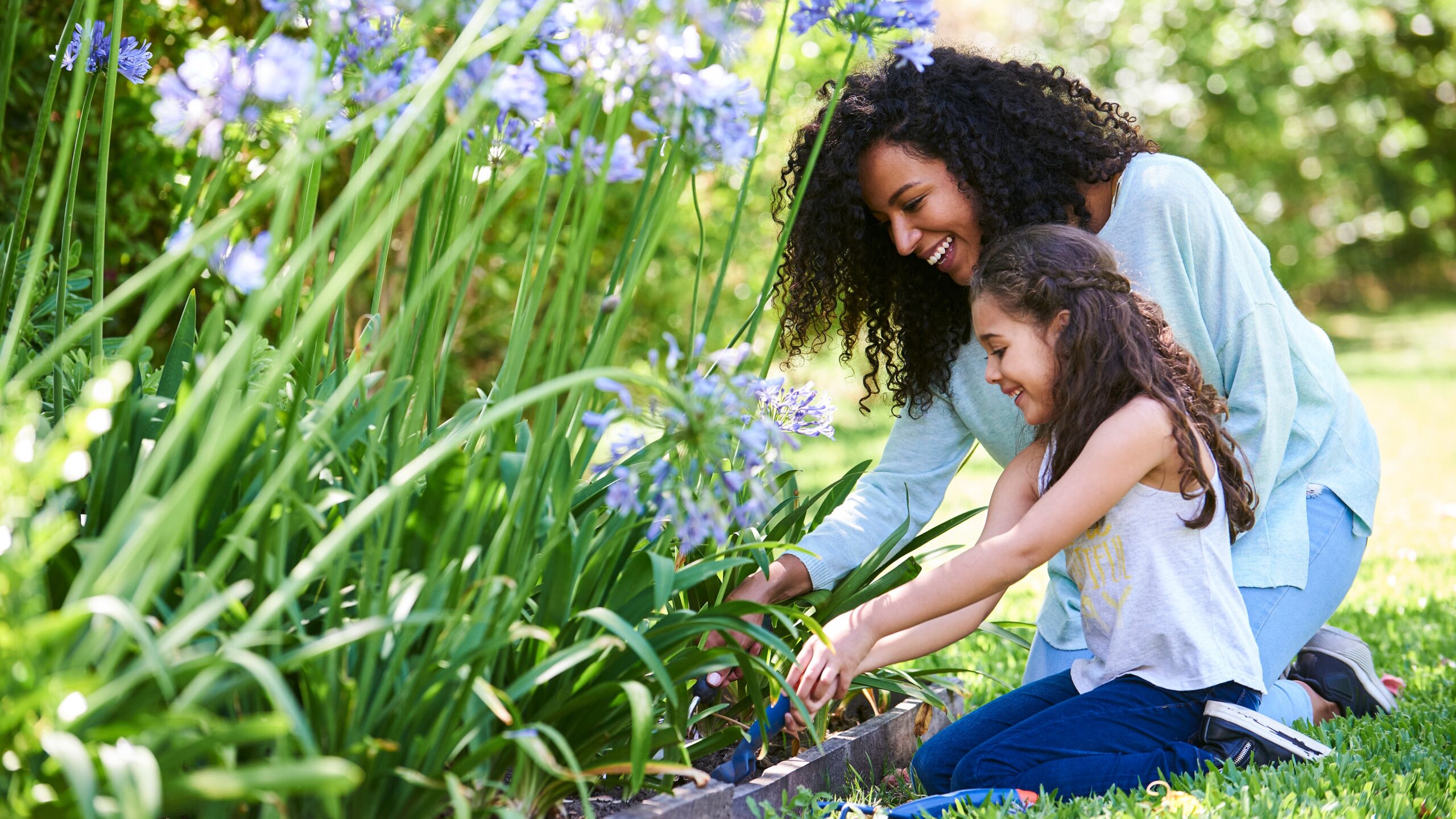 madre e hija plantando planta