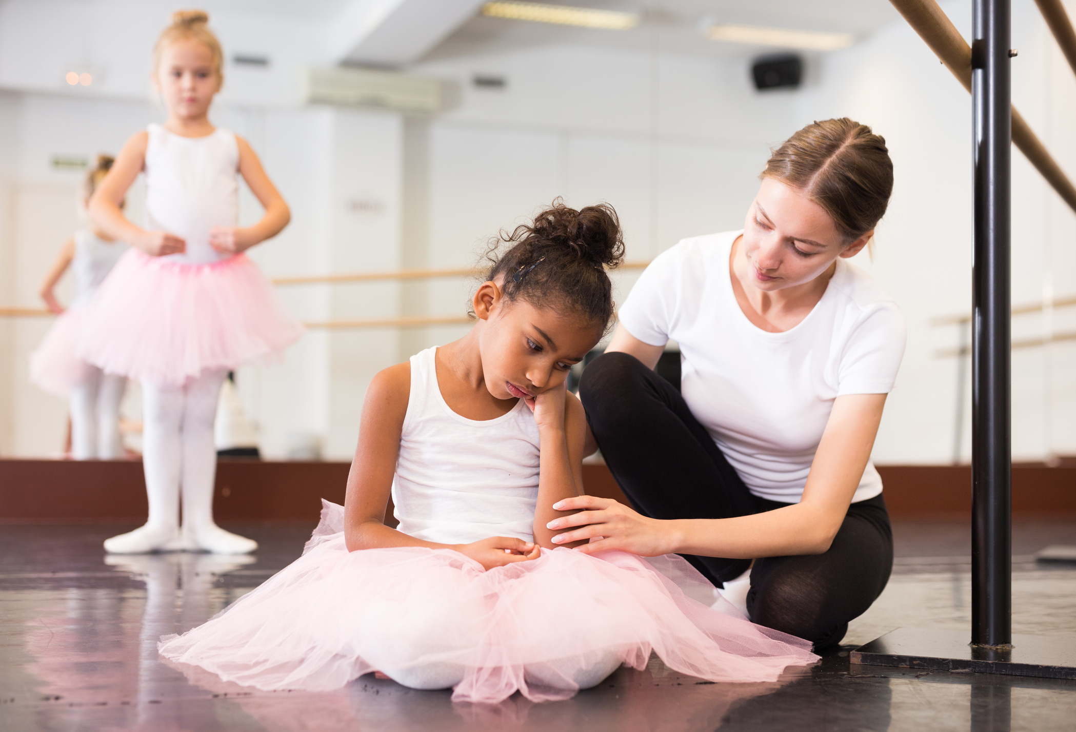 Trainer supporting little upset girl