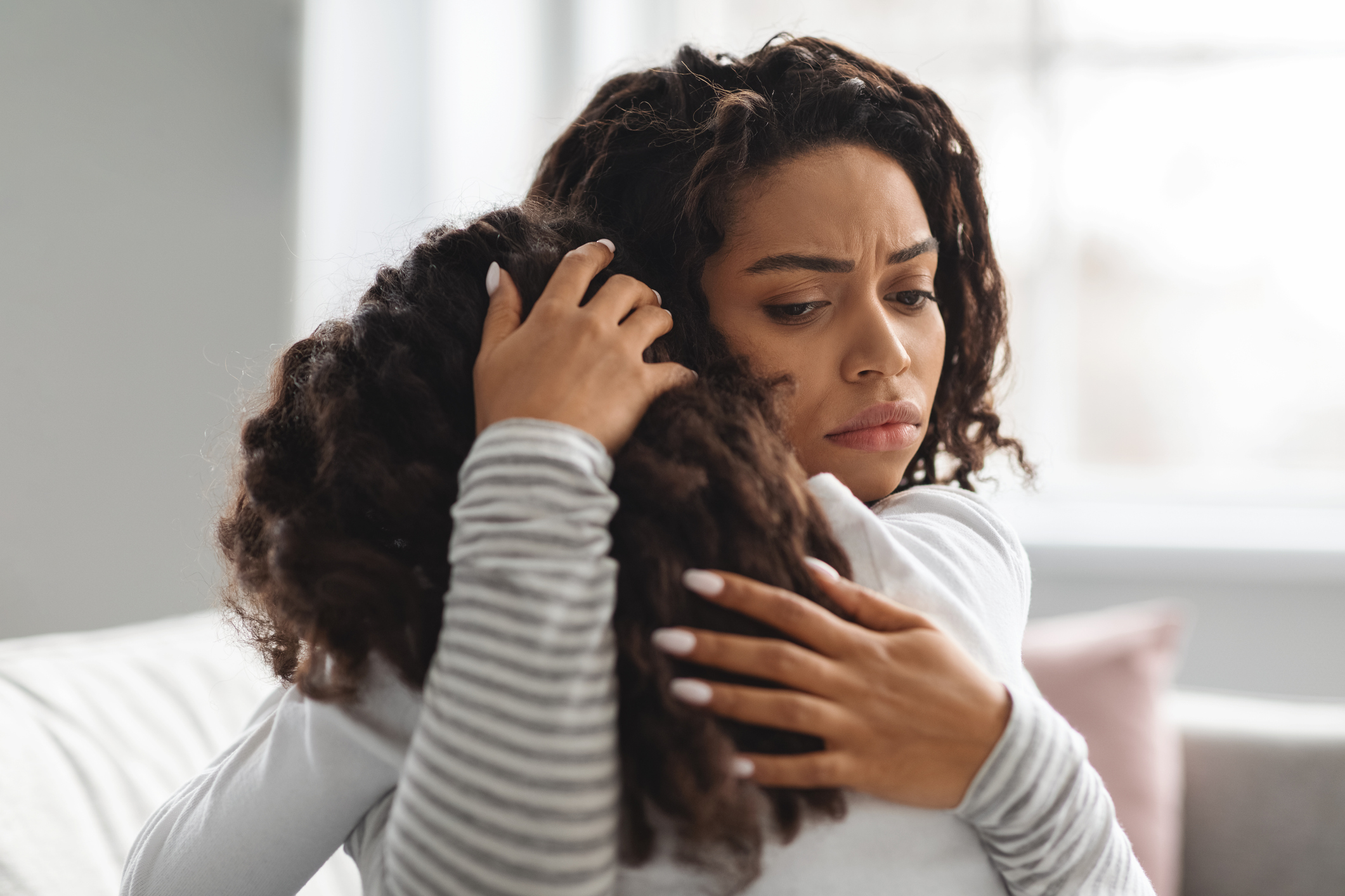 Young black mother comforting her crying daughter