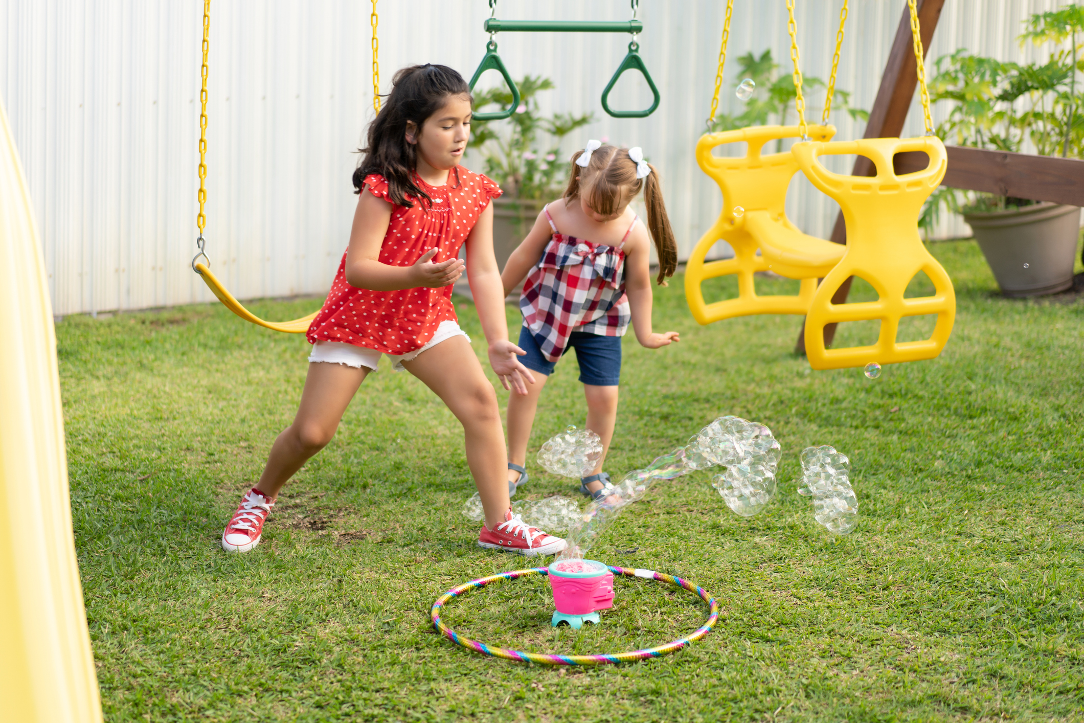 Cousins playing on the backyard with a bubble machine