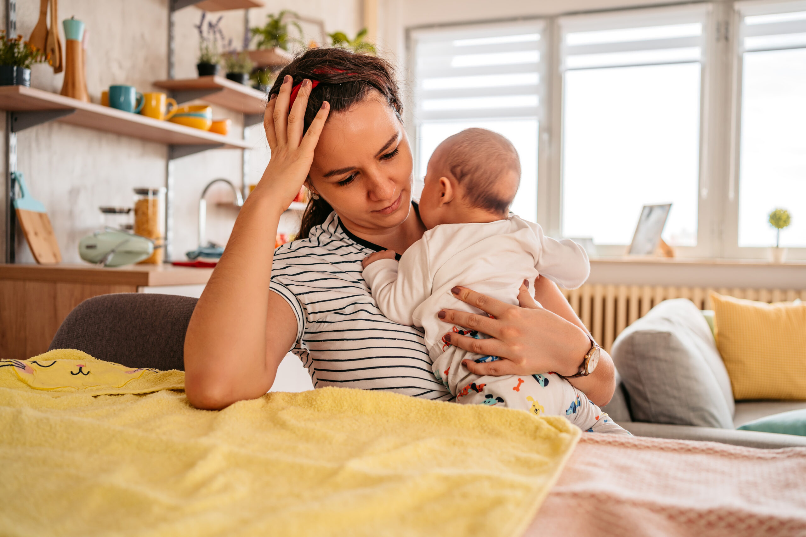 Mother holding her newborn baby feeling sleepy