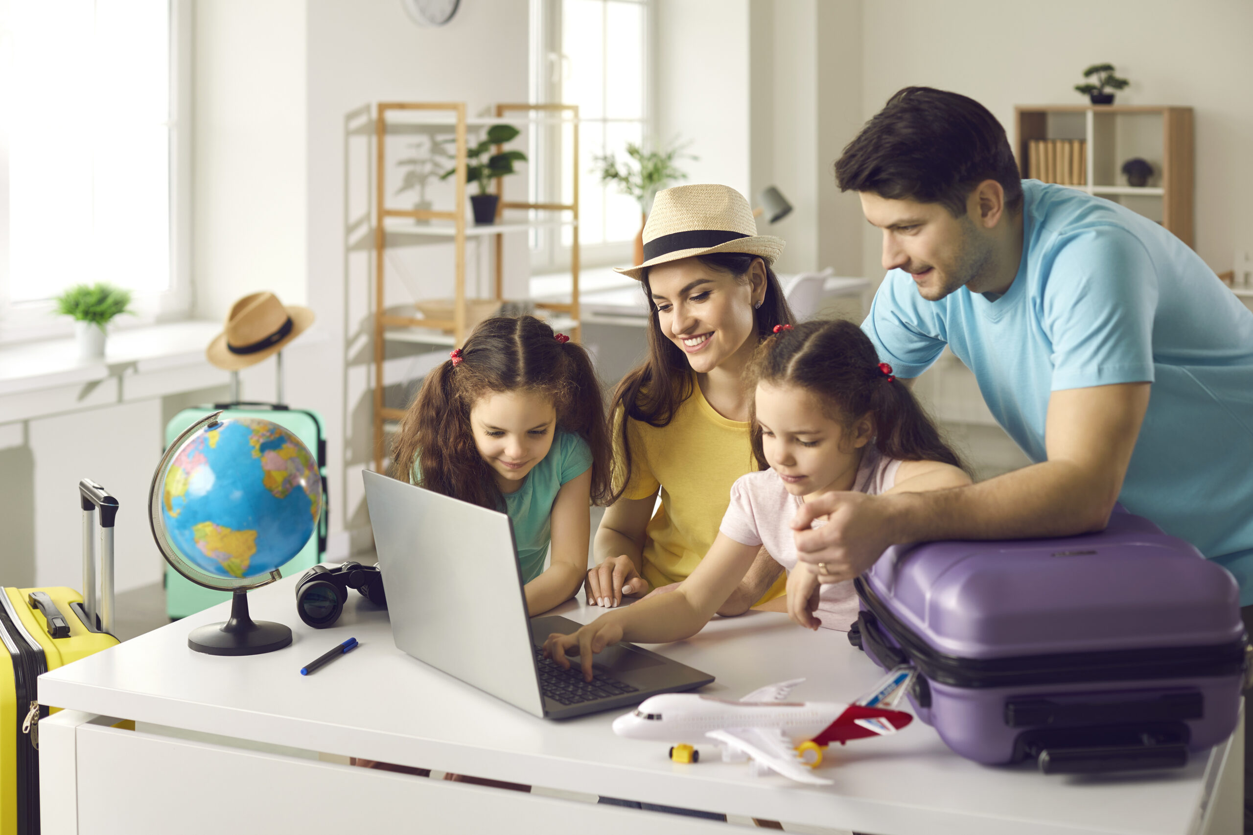 Happy family getting ready for holiday trip and using laptop computer for research