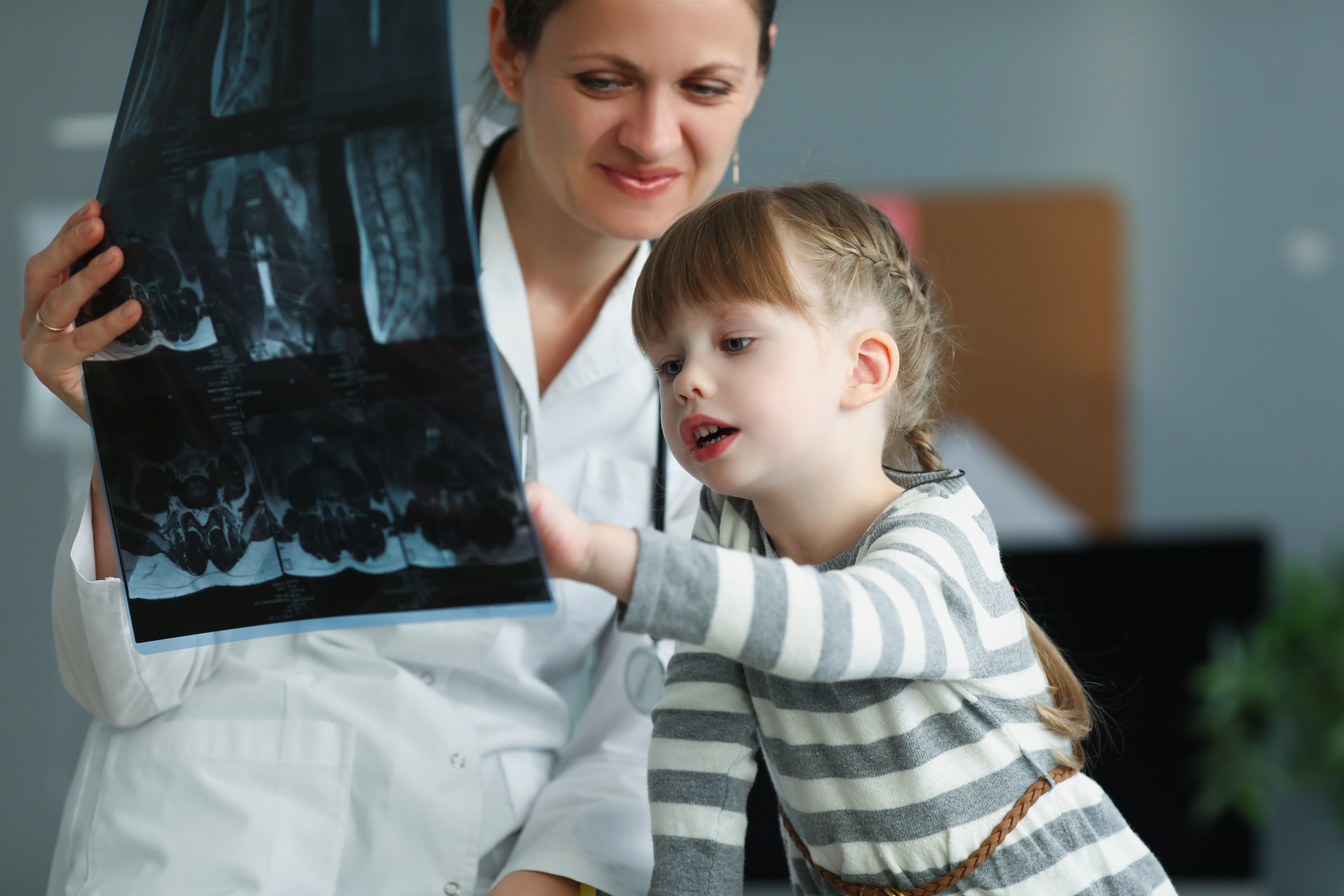 Woman doctor showing little girl xray in clinic