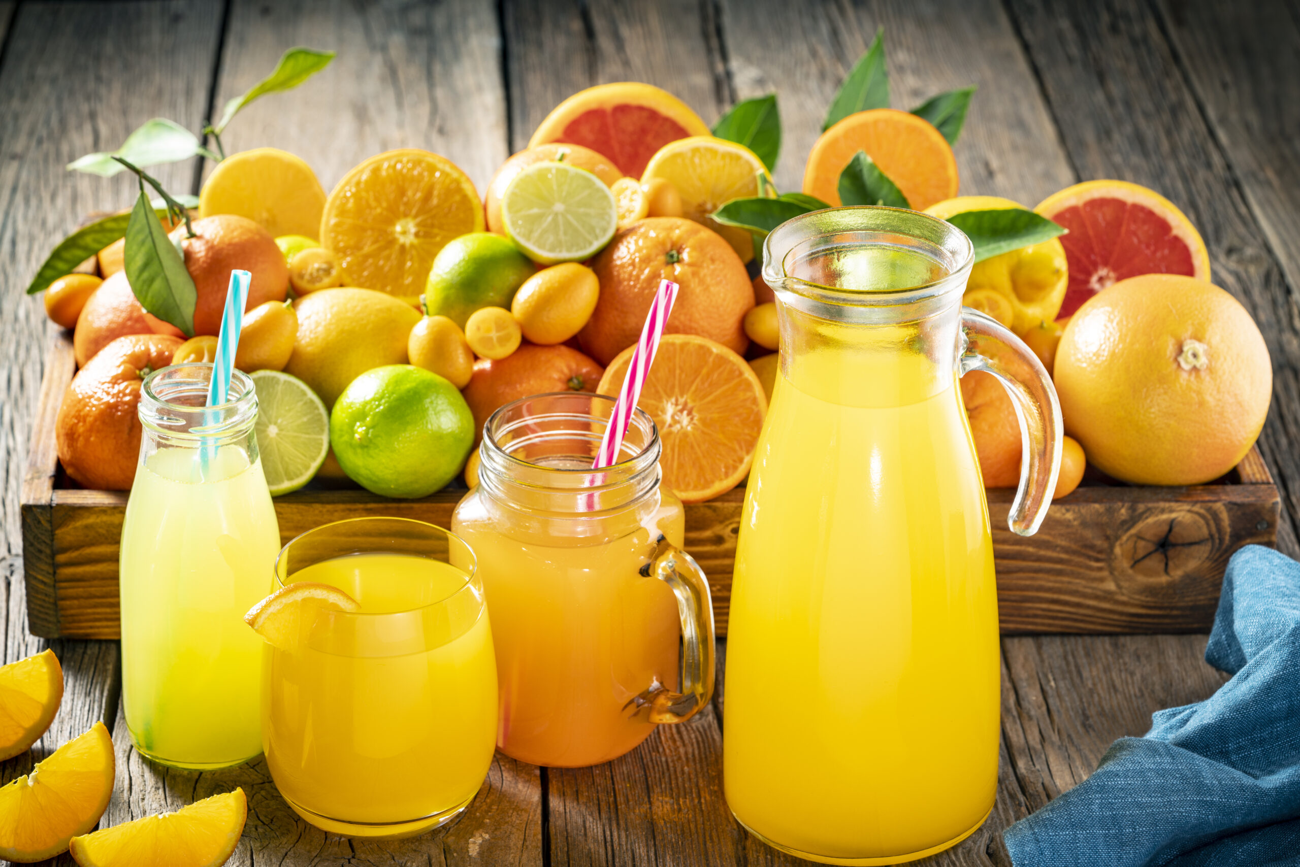 Assorted citrus fruits juice as Orange juice, lemonande and mandarine juice on rustic wood