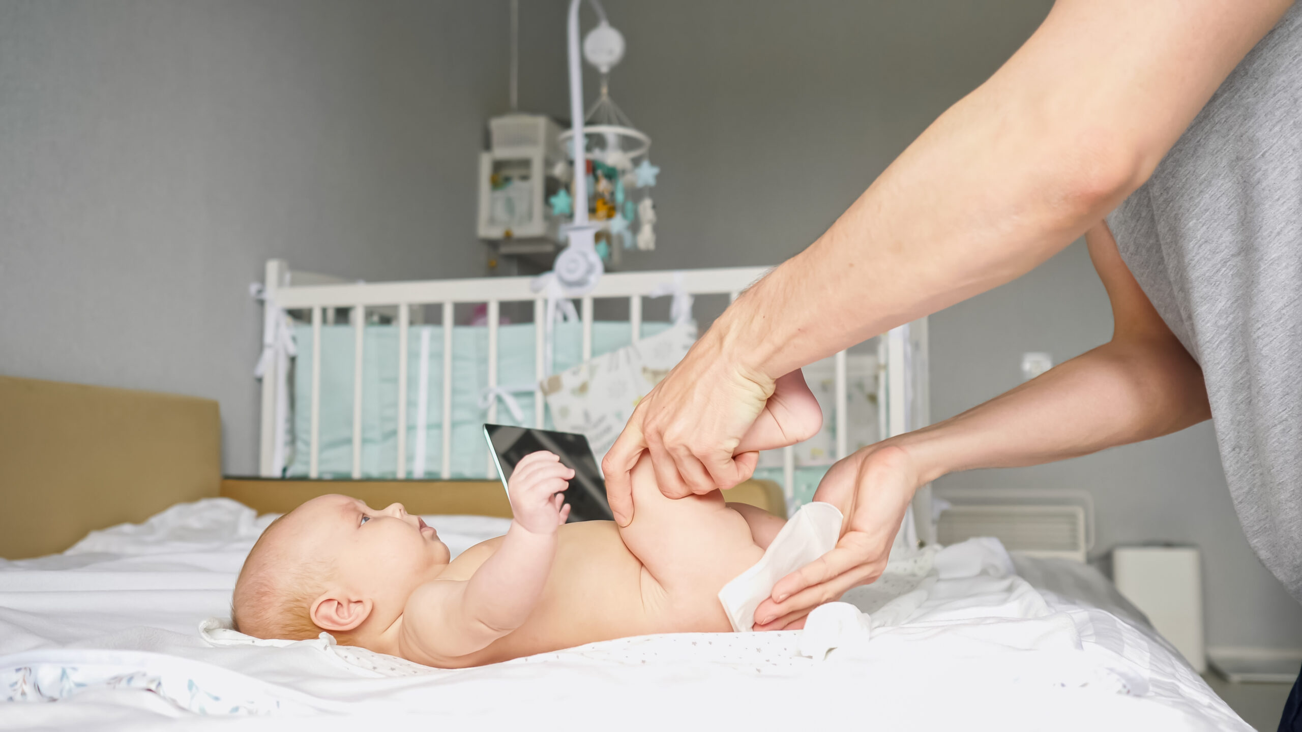 Young father watches instructional video to change diaper