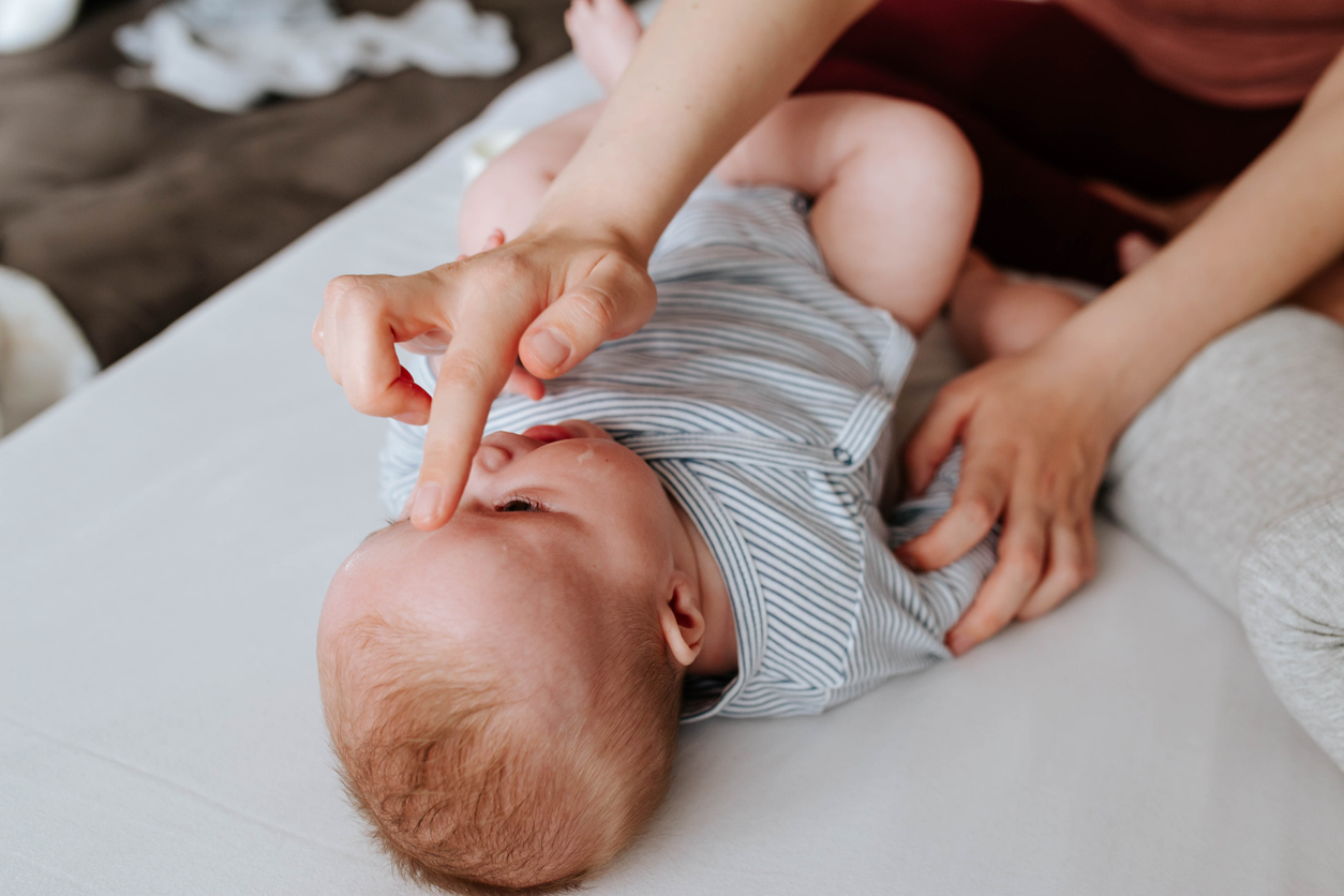 Mother applying baby cream on her baby