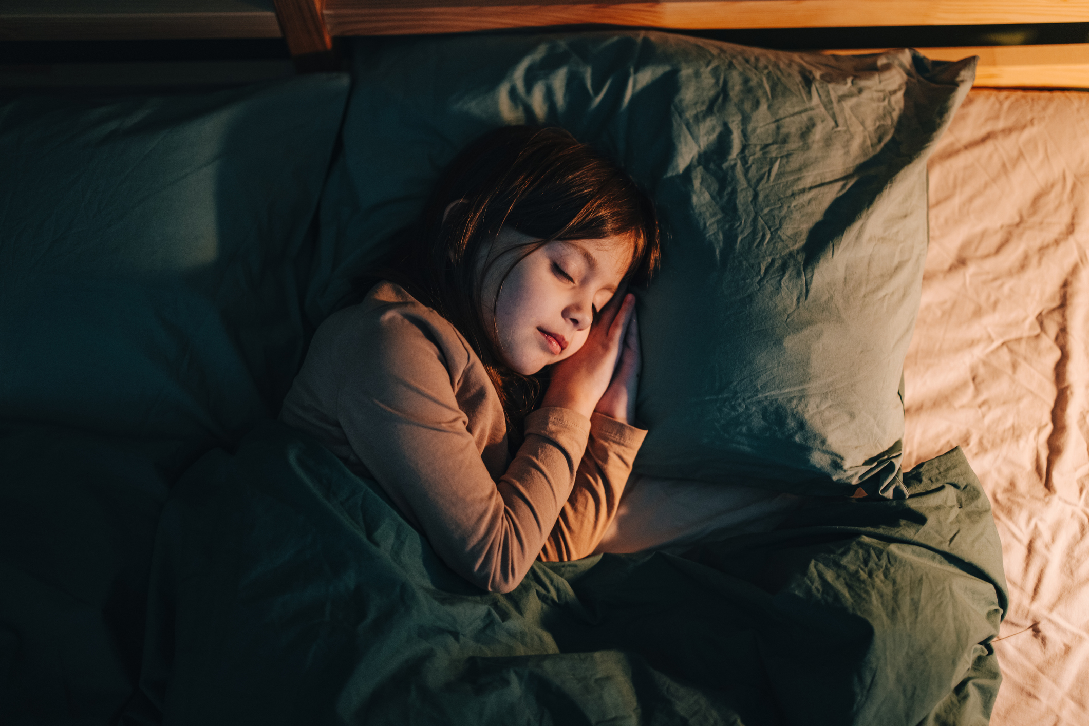 High Angle View Of A Little Girl Sleeping In Her Bed At Night