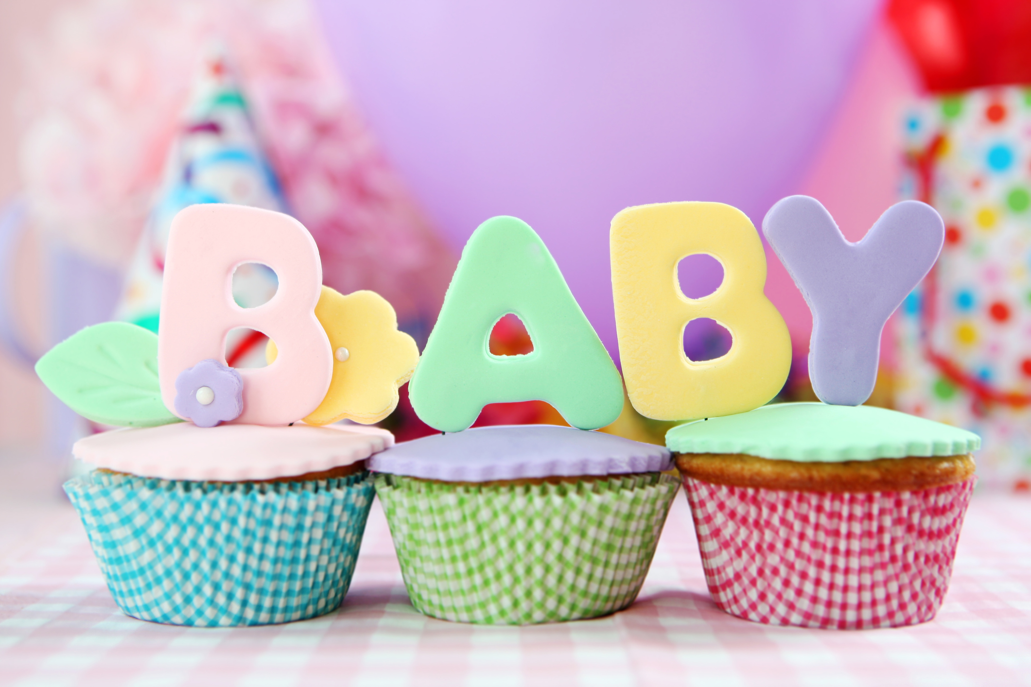 cupcakes de colores con letras encima que dicen baby